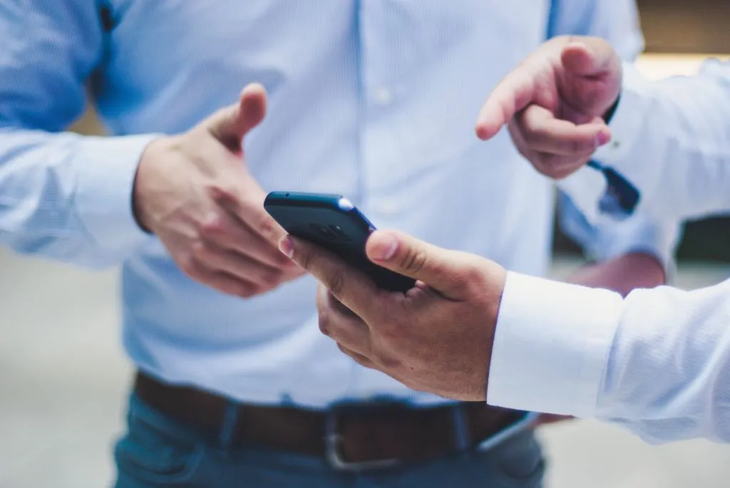 Men pointing at phone demonstrating the concept of Sage X3 Mobile