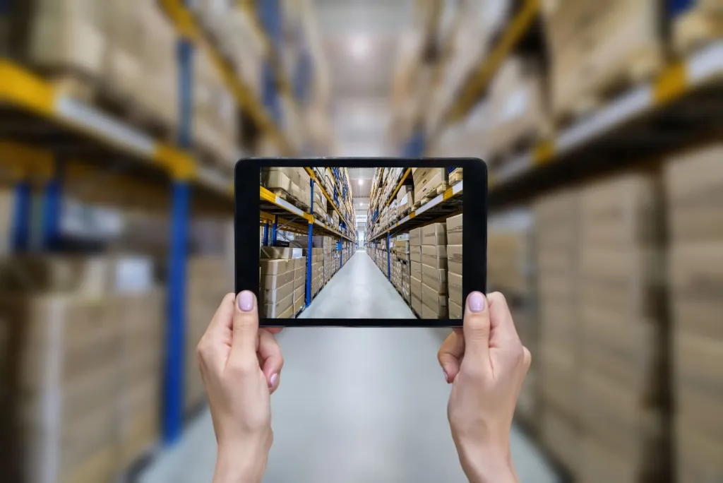 female hands holding tablet in warehouse