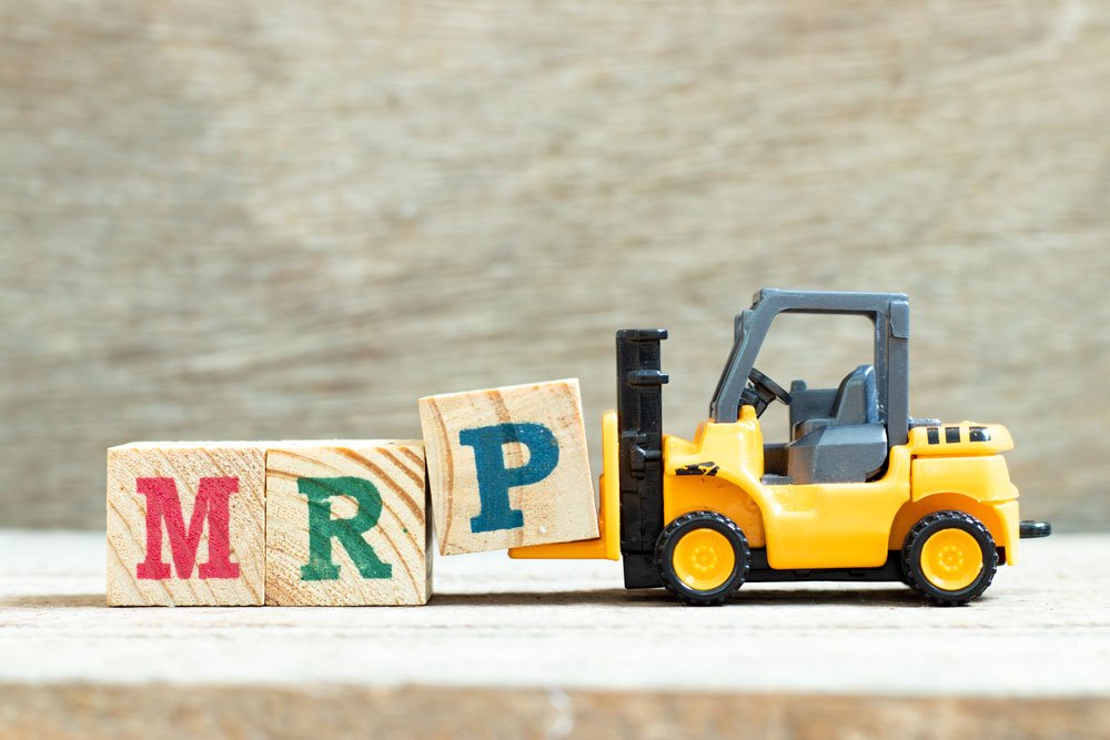 Manufacturing ERP system - yellow toy tractor with wooden blocks spelling MRP