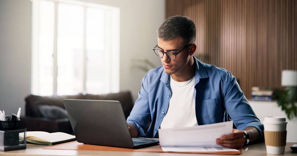 Sage Intacct Health Check - Man comparing notes with online system