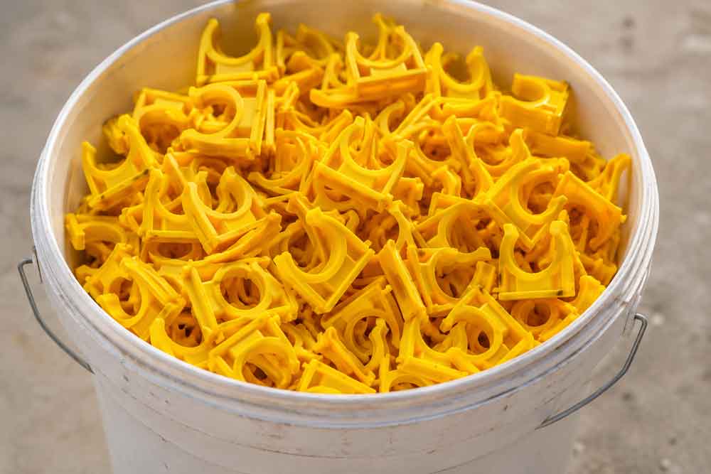 Talon-Manufacturing—bucket Bucket of yellow pipe clips